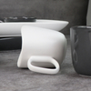 Canecas de cerâmica preta e branca sob copos de porcelana esmaltada
