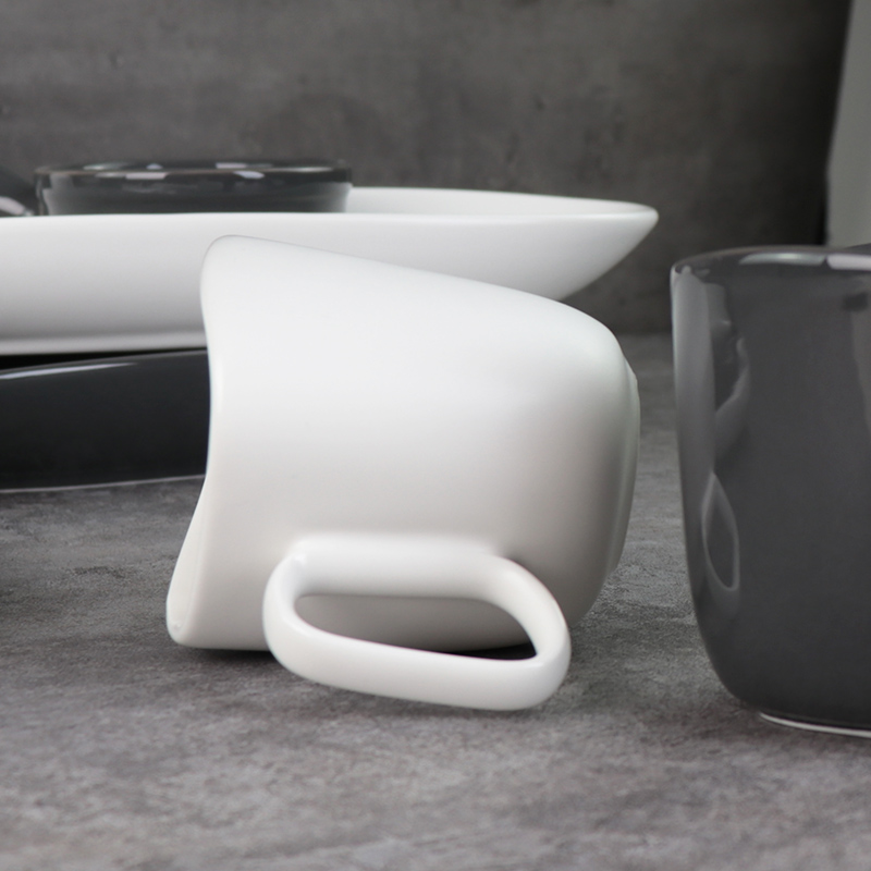 Canecas de cerâmica preta e branca sob copos de porcelana esmaltada