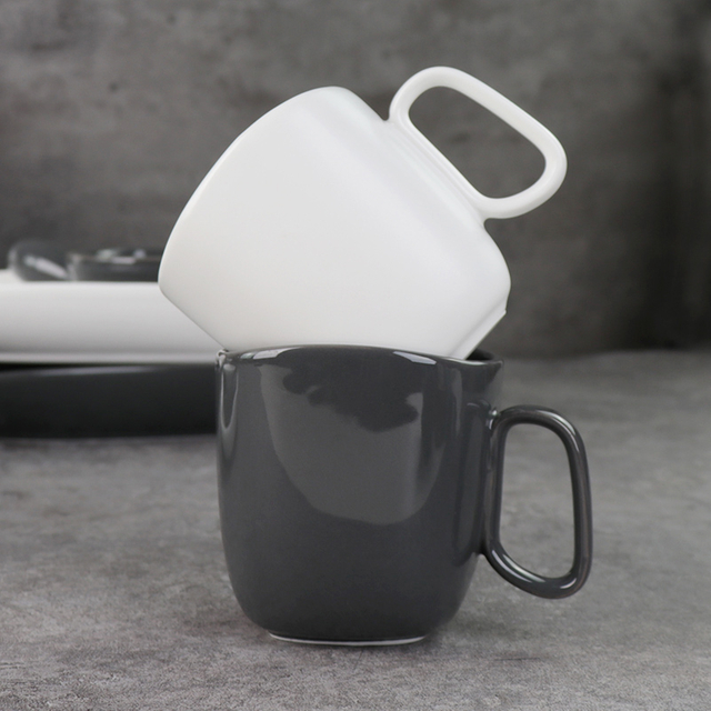 Canecas de cerâmica preta e branca sob copos de porcelana esmaltada