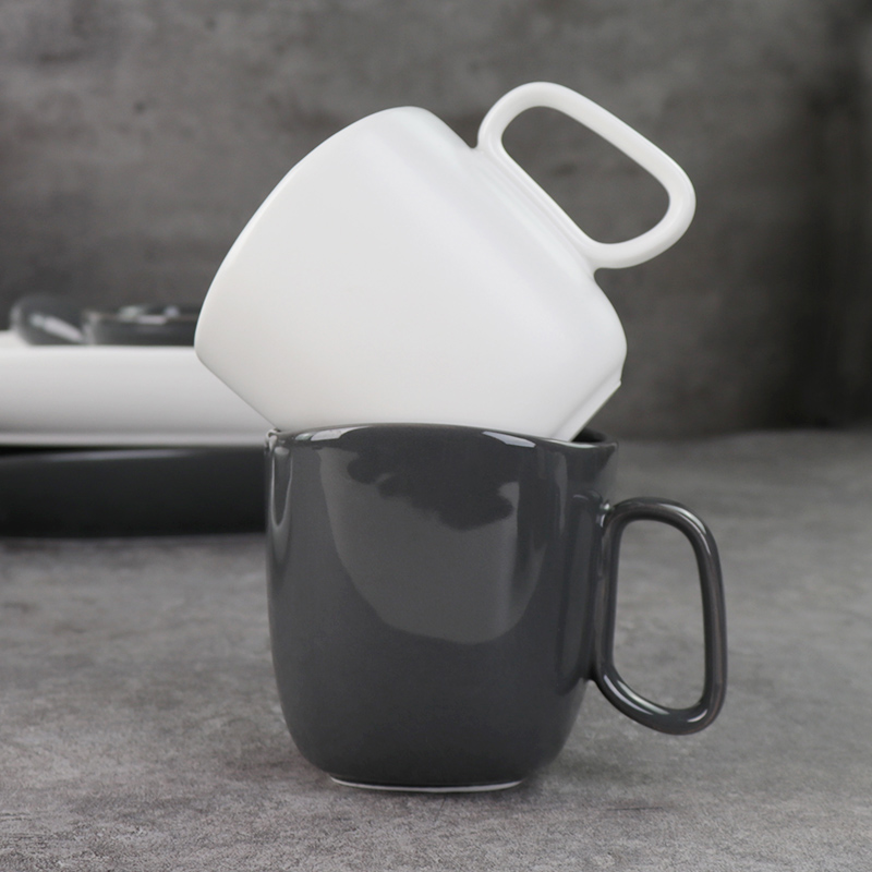 Canecas de cerâmica preta e branca sob copos de porcelana esmaltada