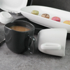 Canecas de cerâmica preta e branca sob copos de porcelana esmaltada