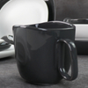 Canecas de cerâmica preta e branca sob copos de porcelana esmaltada